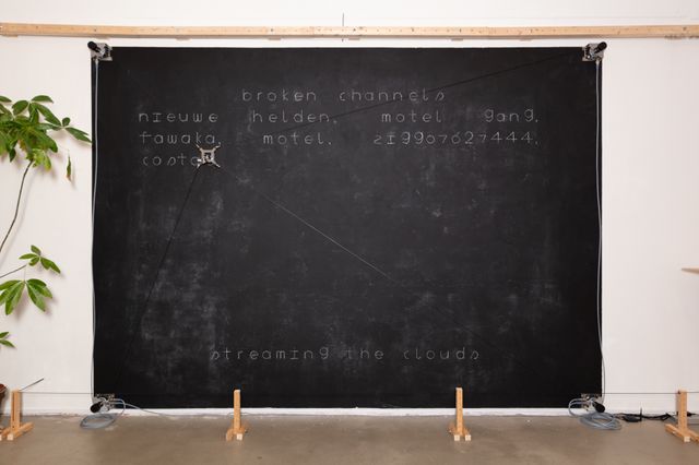 Photograph of a plotter plotting names on a chalkboard